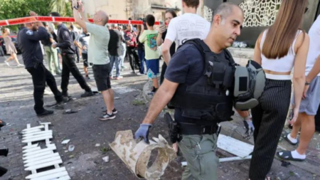 The military person carrying the remnants of the rocket that attacked