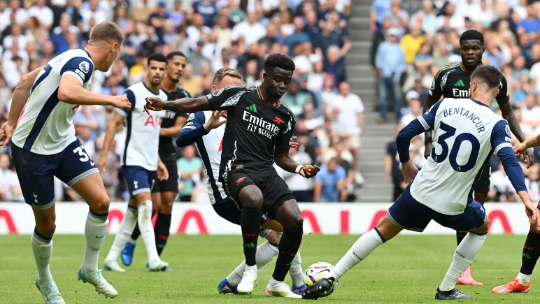 Bukayo Saka surrounded by Tottenham players