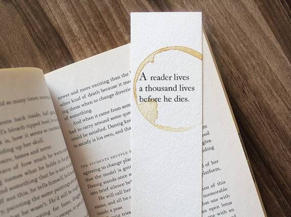 Inspiring book quote in aa bookmark placed over a paperback novel.