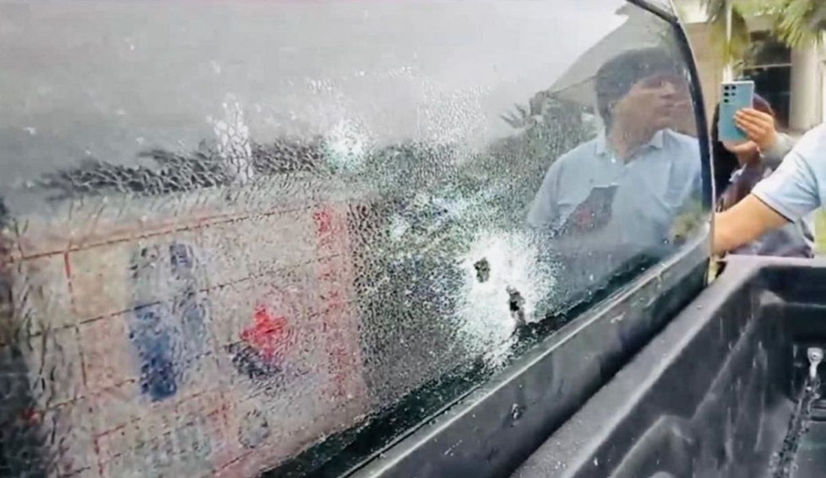 Screenshot of a video showing reflection of Bolivia's  former President Evo Morales in bullet-shattered truck window