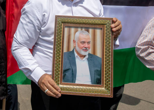 TEHRAN, IRAN - JULY 31: Members of Tehran University Council attend a protest to condemn the killing of Hamas leader Ismail Haniyeh, as they carry Iranian and Palestinian flags at Tehran University, July 31, 2024 in Tehran, Iran. Hamas political leader, Ismail Haniyeh, was killed in an airstrike in Tehran after attending the inauguration of Iran's new president. Israel has yet to claim responsibility for his death.