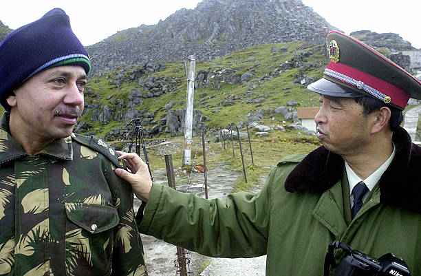 NATHU LA PASS, INDIA:  TO GO WITH STORY 'INDIA-CHINA-NORTHEAST-TRADE' (FILES) In this photograph dated August 2003, a Chinese soldier (R) interacts with an Indian soldier at the Nathu La Pass area at the India-China border in the north-eastern Indian state of Sikkim.  The world's two most populous countries, India and China, are working to set up their first direct trade link since a 1962 border war by reopening a section of the famed Silk Road, Indian officials said 11 September 2005.