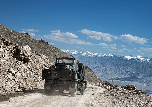 Transportation of army car on a truk among scenic mountain landscape