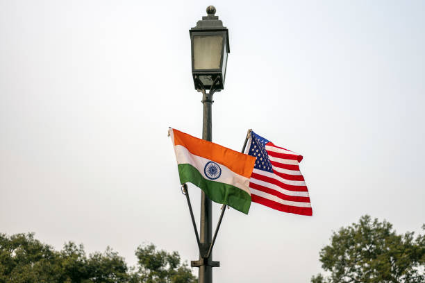 The national flags of India and America hang from a lamppost in New Delhi, India.